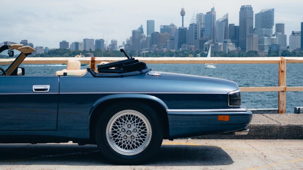 1993 Jaguar XJS 6.0 Convertible in side profile by the water with the Sydney CBD skyline behind