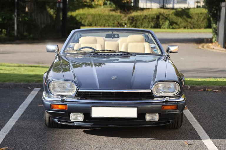 How We Work Jaguar XJS V12 Convertible in dark blue with roof down and magnolia leather seats, front view